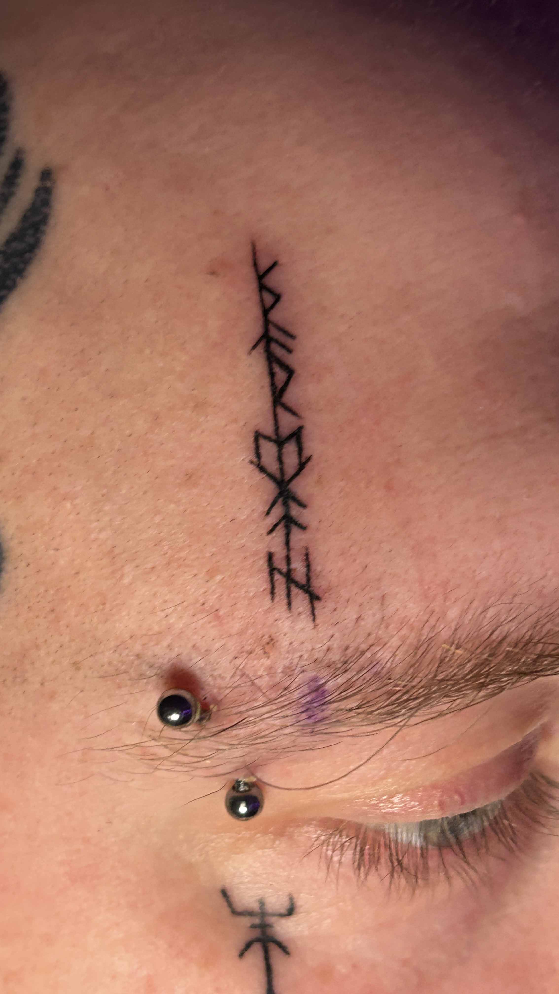 Runes on brow tattoo